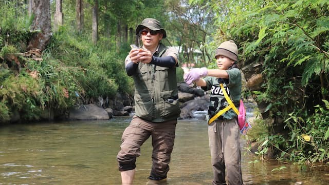 ola dan ayah memegang ikan yang akan ditebar